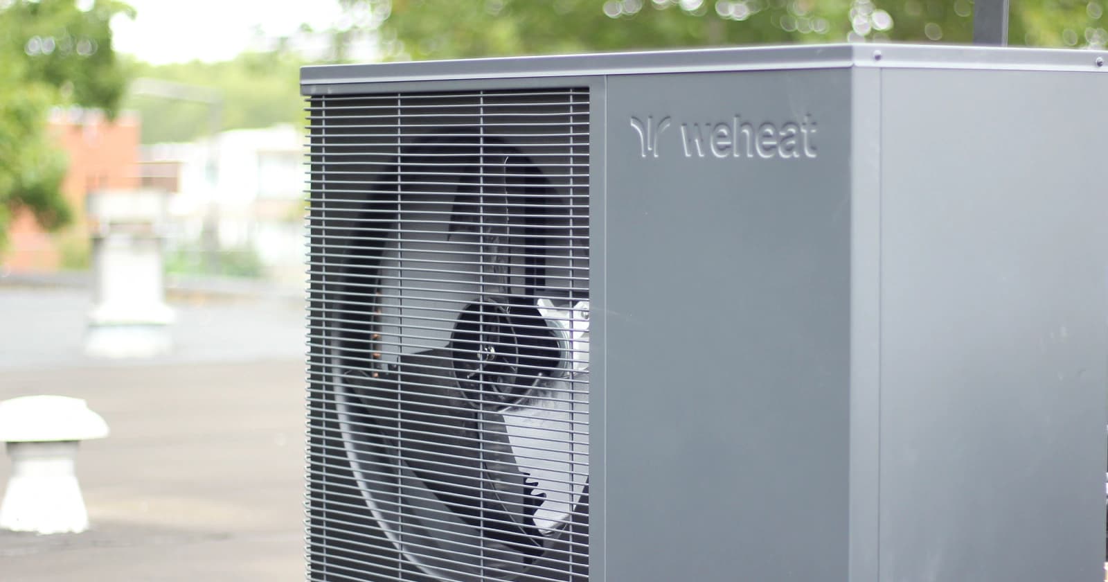 Grijze WeHeat warmtepomp-buitenunit op een plat dak